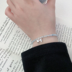 S925 sterling silver bowknot bracelet with light blue aquamarine beads on a female wrist