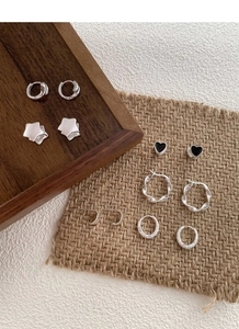 Detailed collection of minimalist S925 silver stud earrings and hoops on wooden tray