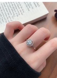Dettaglio macro dell'anello moissanite in argento 925 con castone halo sulle dita