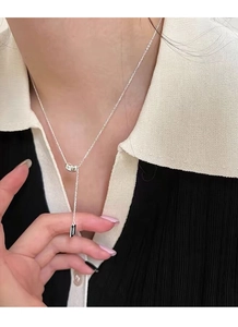 Detail showing S925 silver lucky pendant with tassel and polished bean on neck