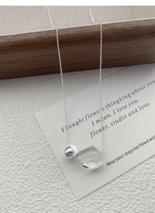 Close-up of irregular crystal pendant with 925 silver bead on a minimalist chain