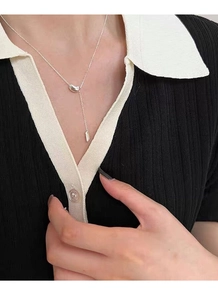 Detail of S925 sterling silver bean necklace with lucky square tag on model neck