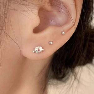 S925 sterling silver heart and knot stud earring set shown on model's ear