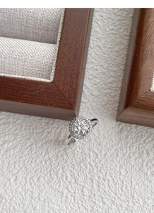 Vista macro di un classico anello halo in argento con moissanite rotonda e pavé di diamanti
