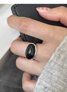 Dettaglio dell'anello in argento S925 con pietra nera ovale indossato sulla mano
