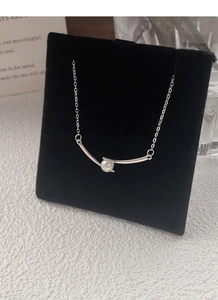 Detailed view of white freshwater pearl on geometric silver pendant and chain necklace
