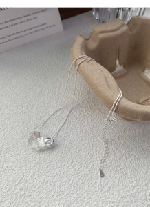 Detailed macro shot of S925 sterling silver chain with crystal bead and silver ball pendant
