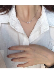 Macro shot of S925 silver necklace featuring a curved bar pendant and a freshwater pearl