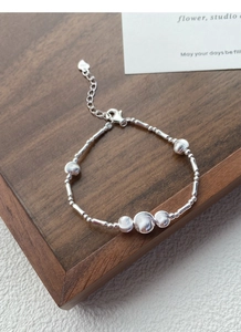 Detailed macro of S925 sterling silver beaded bracelet showing hallmark and heart charm