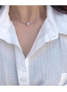 Close-up of a French minimalist S925 silver necklace with pearl on a model's neck