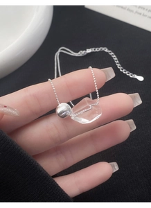 Detailed macro view of S925 silver beaded chain with geometric crystal pendant on hand