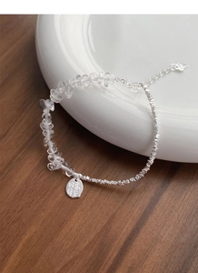 Macro view of S925 sterling silver chain with white crystal beads and luck charm