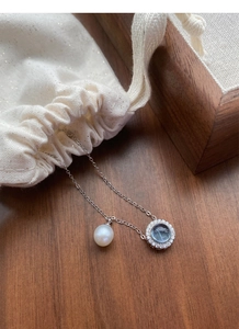 Detail of S925 sterling silver necklace with freshwater pearl and blue aquamarine pendant