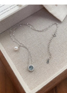 Detail of S925 sterling silver necklace showing blue gemstone and freshwater pearl