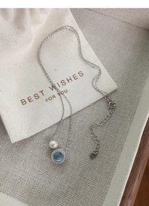 Detail of S925 sterling silver necklace with blue aquamarine, pearl, and jewelry bag