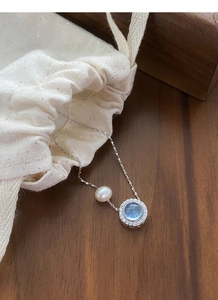 Close-up of S925 silver necklace with aquamarine stone and freshwater pearl
