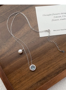 Close-up of S925 sterling silver necklace with blue gemstone pendant and freshwater pearl
