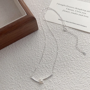 Elegant S925 sterling silver necklace featuring a central freshwater pearl on a curved bar