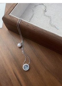 Macro detail of S925 silver necklace with aquamarine pendant and fresh water pearl drop