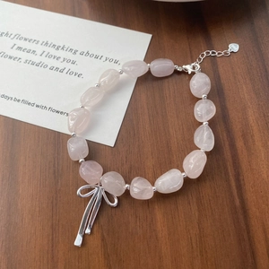 Rosa Quarz Armband mit S925 Silberschleife auf dunklem Holzgrund im süßen Design