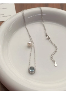 Close-up of S925 silver necklace featuring a blue gemstone and elegant freshwater pearl