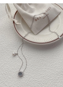 Detailed macro view of S925 sterling silver necklace with freshwater pearl and crystal charm