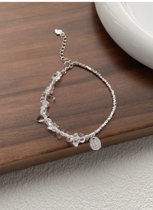 Detailed macro view of S925 sterling silver bracelet with irregular crystal and heart charm