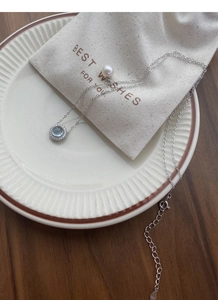 Macro shot of S925 sterling silver necklace with light blue gemstone and freshwater pearl