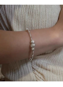 Close-up of S925 silver beaded bamboo bracelet on wrist with cat eye beads
