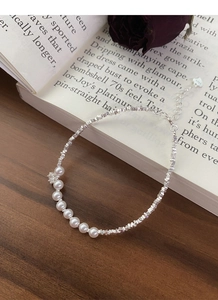 Detail of S925 silver beaded bracelet with freshwater pearls on a vintage book