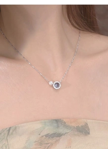 Detail of S925 silver necklace with freshwater pearl and diamond pendant on model neck