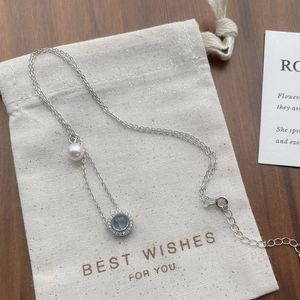 S925 sterling silver necklace with freshwater pearl and blue topaz pendant on gift bag