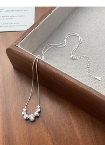 Detail of S925 sterling silver snake chain with graduated brushed beads on wood tray