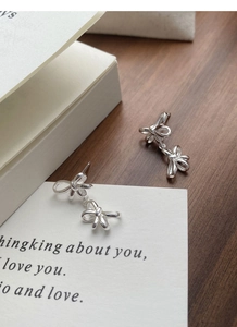 Detail of elegant S925 sterling silver double bow earrings on a white gift card