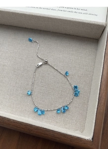 Detail of adjustable 925 sterling silver bracelet with blue teardrop zircon stones