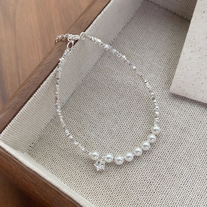 S925 sterling silver pearl bracelet with star pendant on a beige textured tray