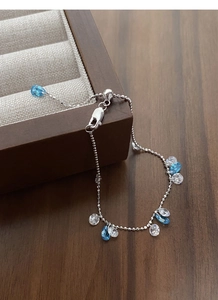 Close-up of 925 silver adjustable bracelet with blue zircon water drop pendants