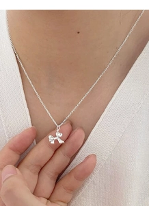Nahaufnahme einer 925er Sterling Silber Schleife Halskette am Hals einer Frau