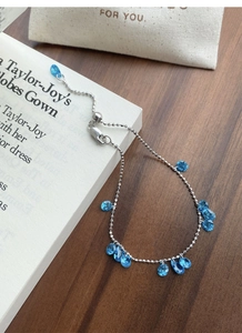 Detail of S925 silver bracelet featuring blue teardrop zircon charms and adjustable closure