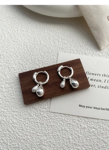 Detail of 925 sterling silver hoop earrings with dual water drop and pearl pendants