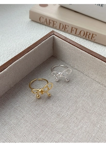 Close-up of S925 sterling silver bow rings in gold and silver with adjustable open bands