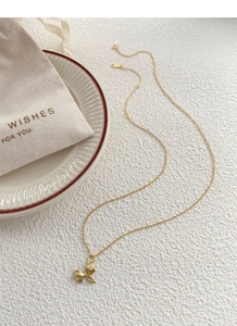 Nahaufnahme der S925-Punze einer goldenen Schleifenkette auf einem Keramiktablett