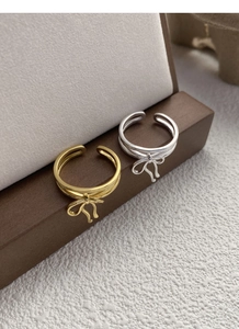 Detail view of gold and silver bow rings with double-layer open adjustable bands