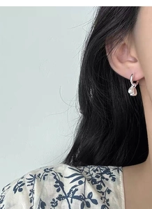 Close-up of 925 silver teardrop pearl earring worn on model for a sweet, elegant look