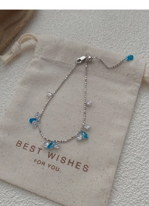 Close-up of 925 silver adjustable bracelet with blue zircon charms on a gift bag