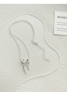 Gros plan du pendentif papillon en argent avec sa chaîne à billes et son fermoir