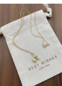 Detail der S925-Punze an der goldenen Schleifenkette mit elegantem Geschenkbeutel