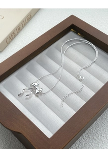 Détail macro du collier papillon en argent S925 avec chaîne à billes sur un présentoir