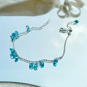 925 sterling silver bracelet with sparkling blue water-drop zircon charms on a mirror