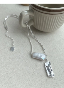 Dettaglio della collana in argento S925 con perla barocca e ciondolo martellato su tazza